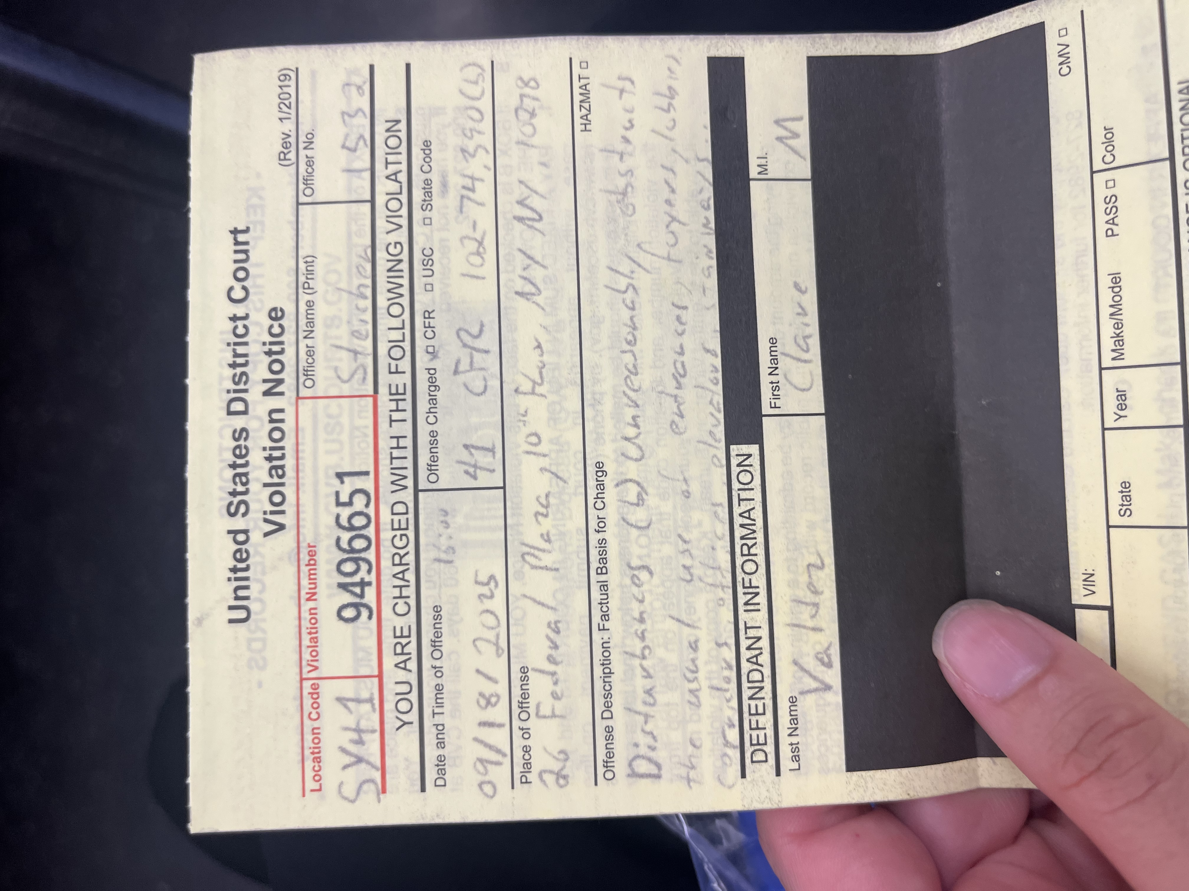 Claire Valdez holds a federal violation notice