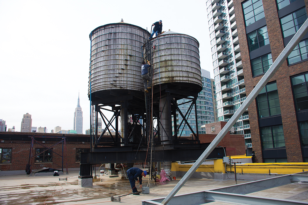 American Pipe and Tank Co. employees inspect a water tank and install a heating device to keep the water tank from freezing in the winter.