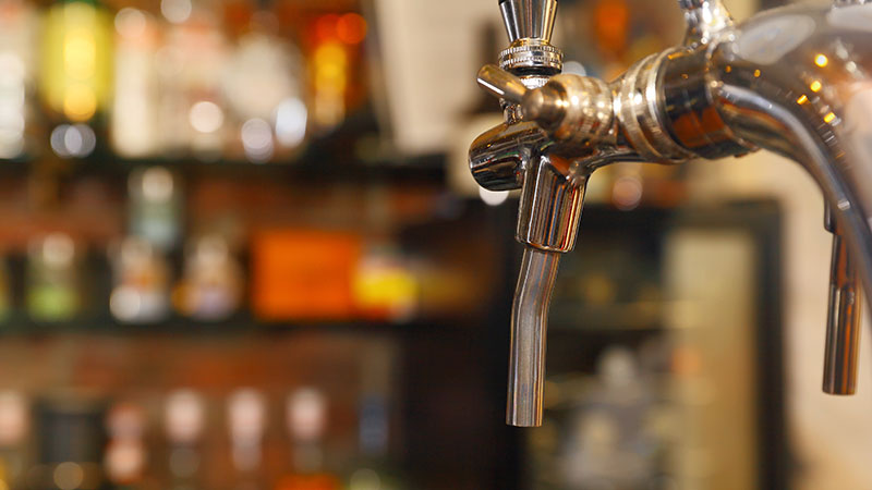 A beer tap at a bar.