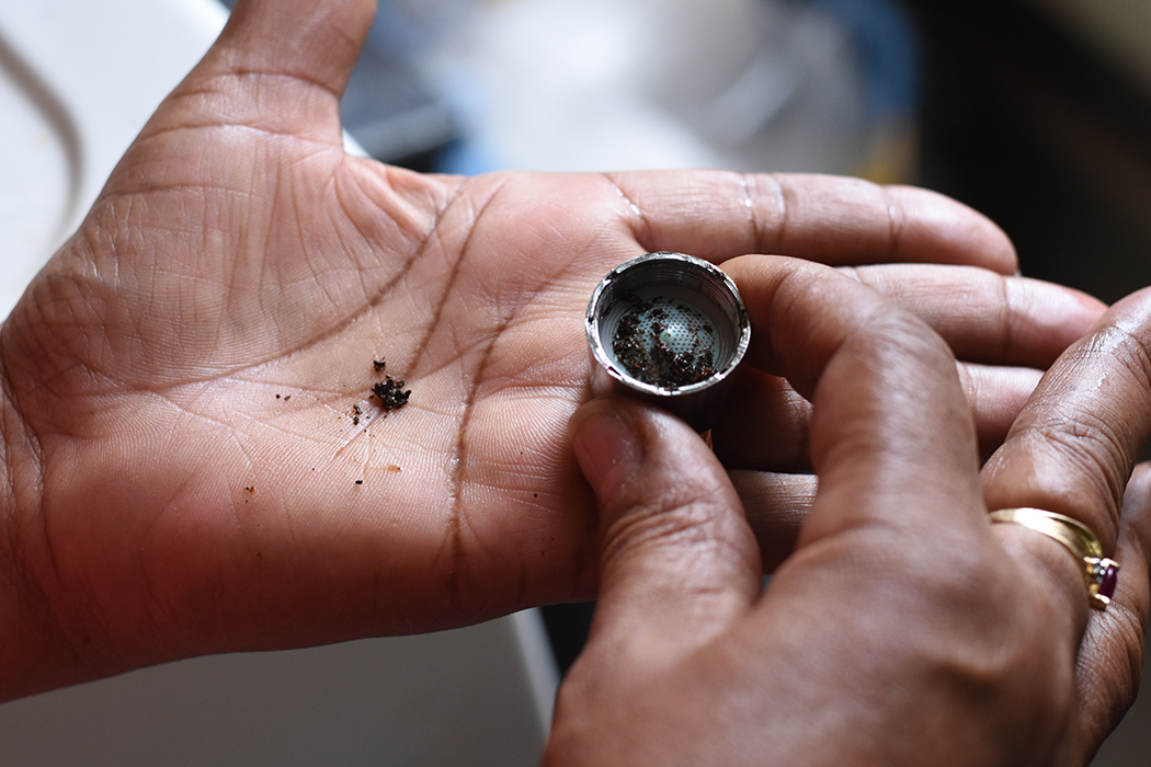 Maria Santos finds small pieces of debris inside the faucet strainer of the kitchen tap in her apartment in NYCHA’s Chelsea Houses Addition building.