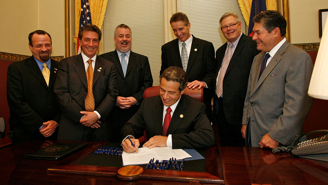 Gov. Andrew Cuomo signing the Marriage Equality Act, with Harry Bronson, Matthew Titone, Daniel O’Donnell, Bob Duffy, Tom Duane and James Alesi.