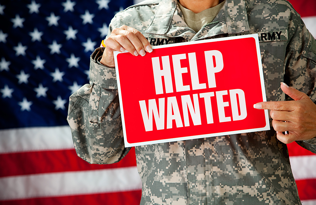 Soldier holding a help wanted sign