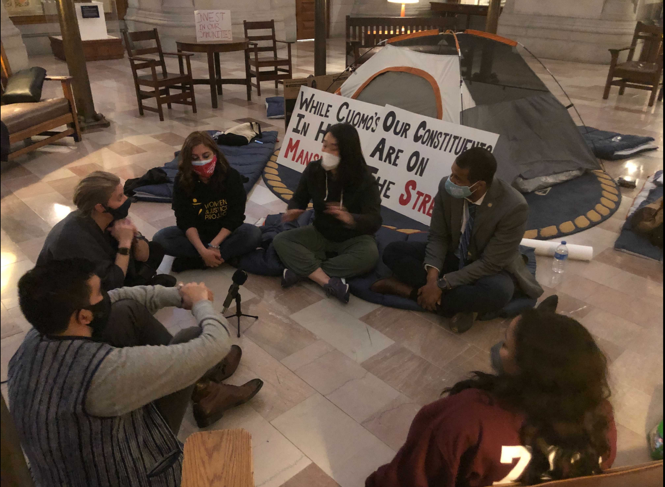 Assemblymembers with a tent set up at the Capitol.