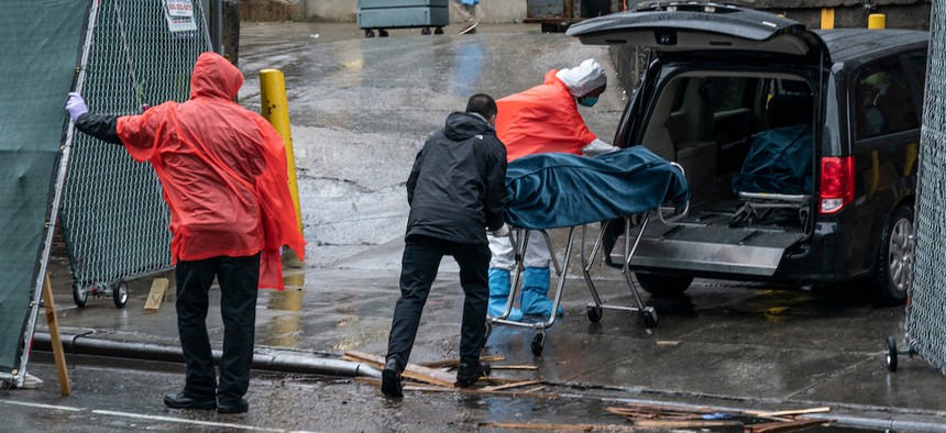Funeral workers and hospital staff retrieve deceased bodies for burial amid COVID-19 pandemic at Brooklyn Hospital Center.