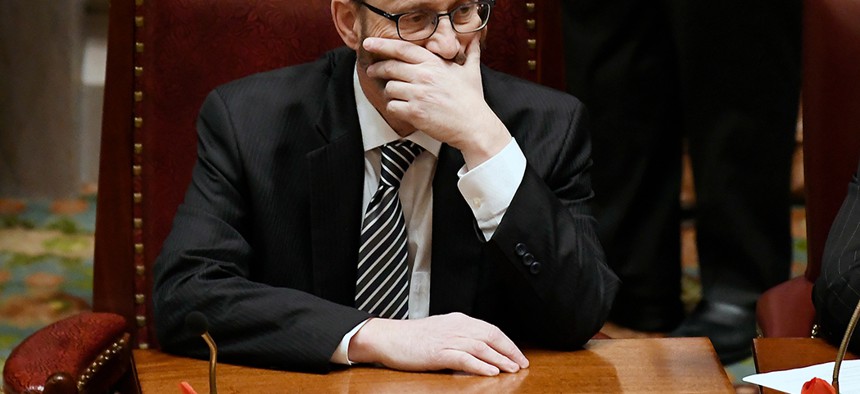 SImcha Felder holds his face in the New York Senate Chambers.