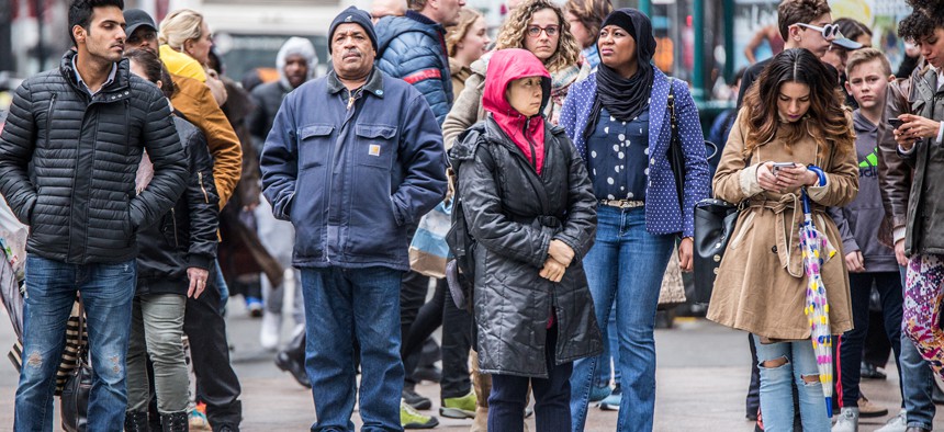 Busy New York City street scene of diversity of pedestrian people crossing the street in Midtown Manhattan on 34th Street Herald Square.