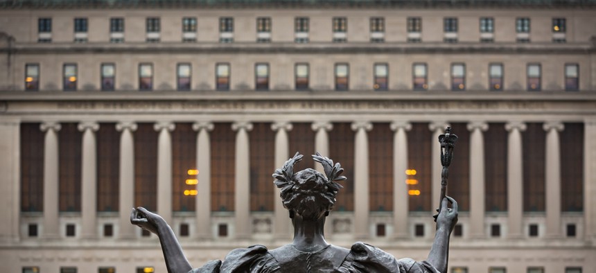 The Columbia University campus with a statue in the foreground.