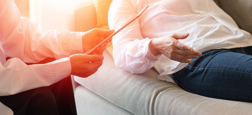 Therapist sits next to reclining patient