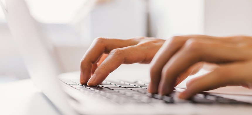 Fingers typing on laptop keyboard