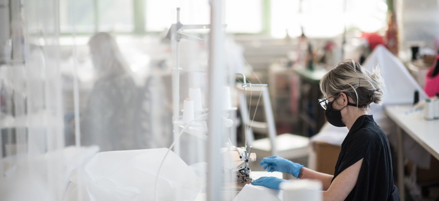 An essential worker at Malia Mills, a fashion garment factory that has been repurposed to produce reusable hospital gowns for frontline healthcare workers.