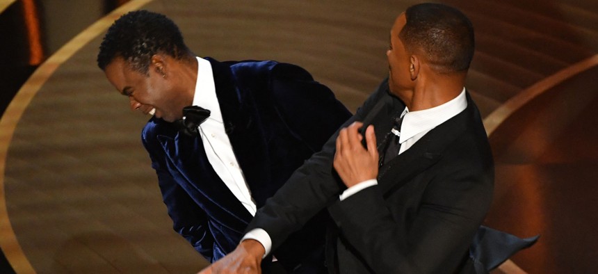 Actor Will Smith (R) slaps actor Chris Rock onstage during the 94th Oscars at the Dolby Theatre in Hollywood, California, on March 27, 2022.