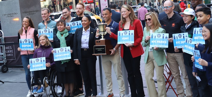 New York Road Runners CEO Rob Simmelkjaer poses with representatives from 8 public service agencies and the mayor’s office competing in this year’s Commissioner’s Cup at a press conference in Times Square Thursday.