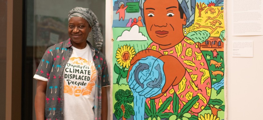 Malado Barro, an immigrant from Mali stands next to an artwork about climate change by Angel Garcia on Sept. 29, 2024.