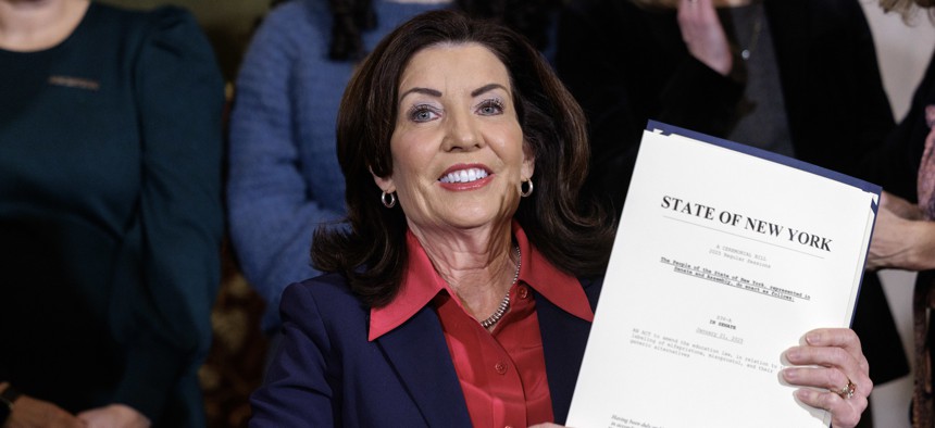 Gov. Kathy Hochul holds up a signed copy of a bill meant to protect the identities of New York doctors who provide abortion medicine, in the state Capitol on Feb. 3, 2025.