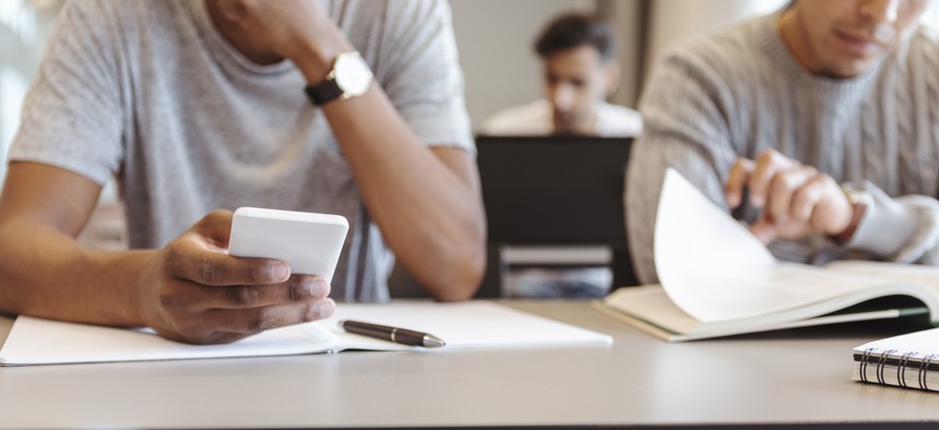 A student uses a phone in a classroom.