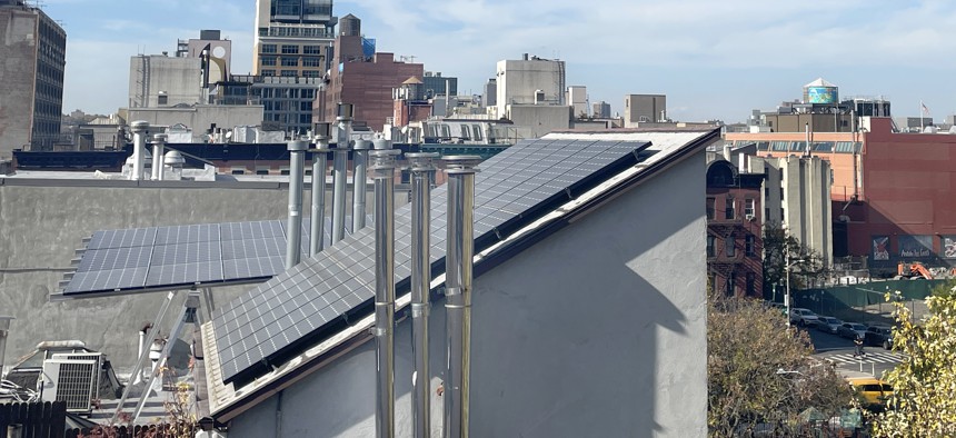 A rooftop view of solar panels installed on a brownstone building in Manhattan.