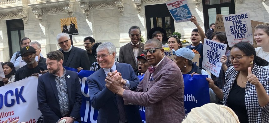 Assembly Member Phil Steck and state Sen. James Sanders hold a rally outside the New York Stock exchange in support of a stock transfer tax on April 23, 2025.